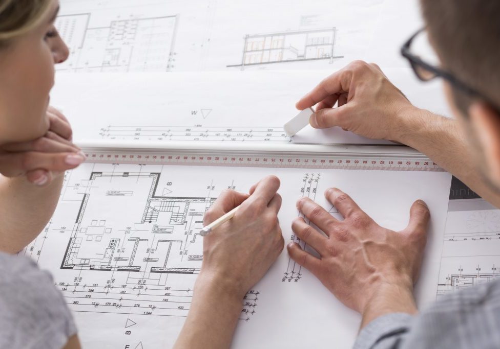 Architects working on some professional drawing View of two focused architects working on some professional drawing